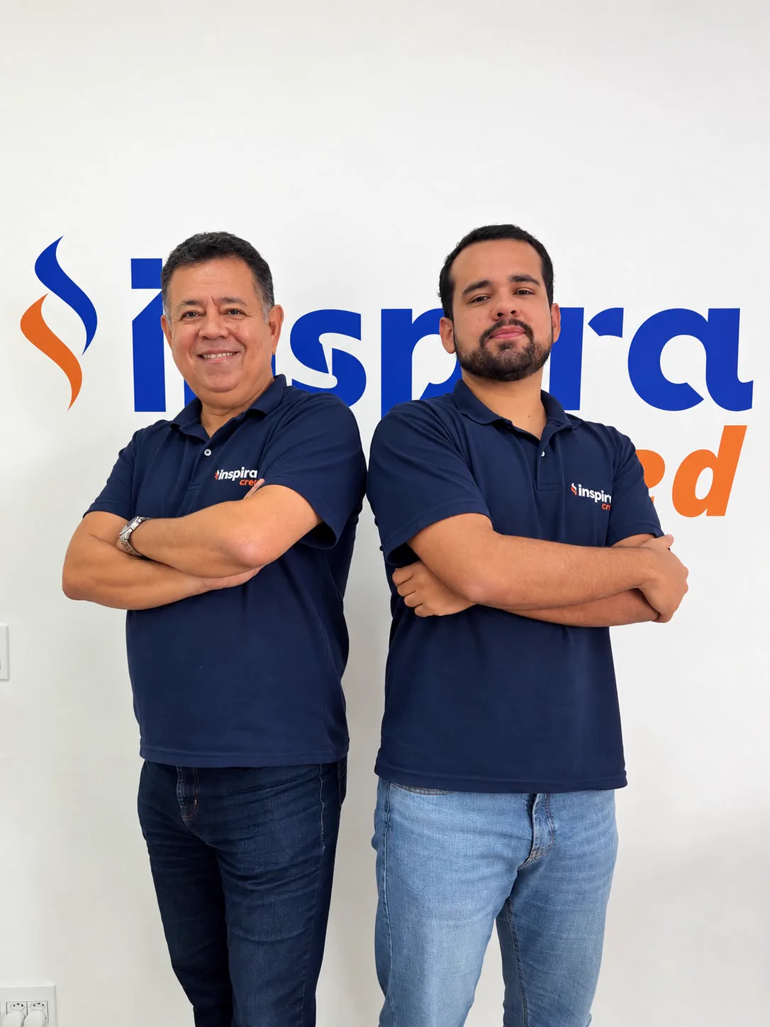 Equipe da InspiraCred reunida no escritório, em frente ao logo da empresa